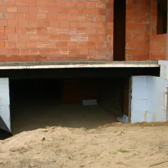 Budowa domu, widoczna piwnica z betonowym fundamentem i ścianami z pustaków. Zastanawiasz się, ile kosztuje piwnica?