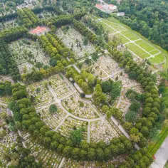 Widok z lotu ptaka na cmentarz centralny w Gliwicach, z alejkami i nagrobkami otoczonymi zielenią.