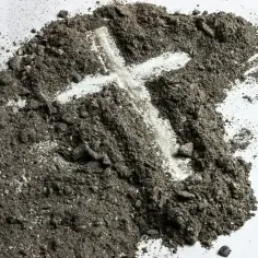 Popiół z wyciśniętym krzyżem na białym tle.