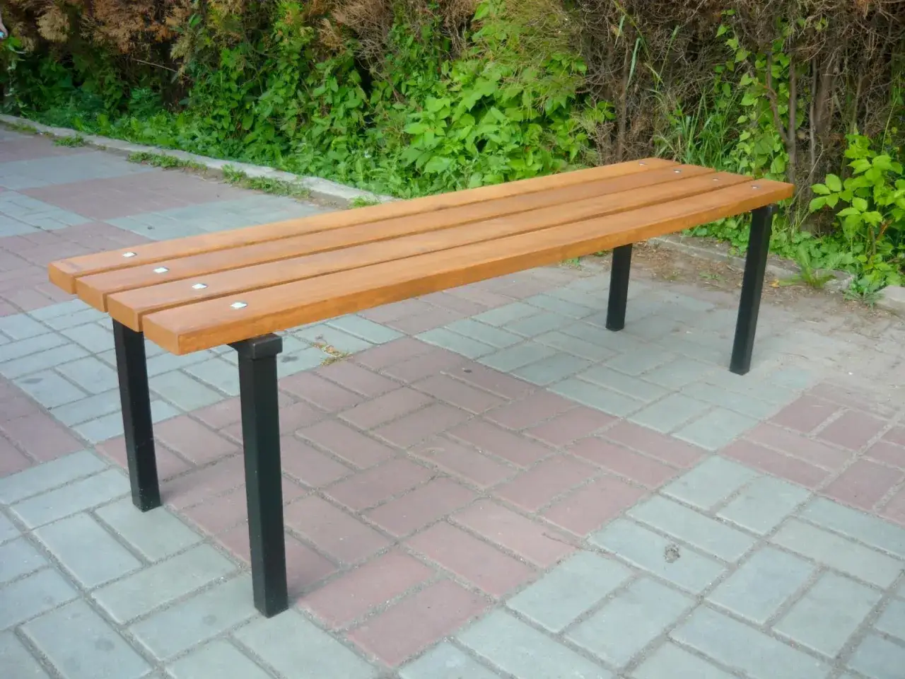 Prosta ławka z drewnianym siedziskiem i metalowymi nogami. Idealna, by usiąść i pomyśleć, jak zrobić ławkę na cmentarz.