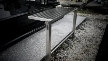 Metalowa ławka na cmentarzu, gotowa do montażu. Jak wkopać ławkę, by służyła latami.