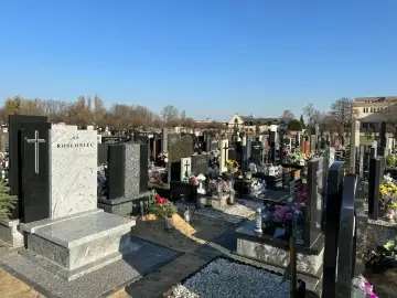 Nagrobki na cmentarzu parafialnym. Zastanawiasz się, ile kosztuje miejsce na cmentarzu parafialnym? Widok wielu grobów z kwiatami i krzyżami.