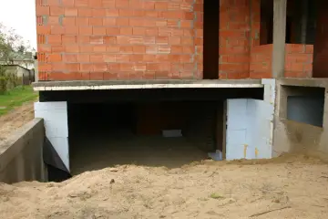 Budowa domu, widoczna piwnica z betonowym fundamentem i ścianami z pustaków. Zastanawiasz się, ile kosztuje piwnica?