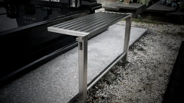 Metalowa ławka na cmentarzu, gotowa do montażu. Jak wkopać ławkę, by służyła latami.